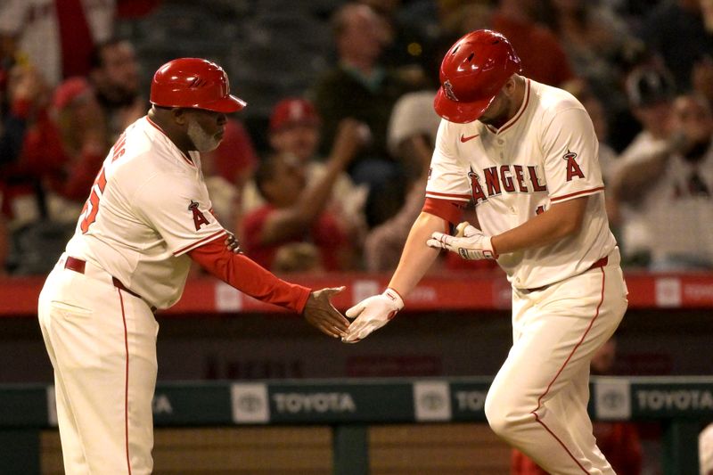 Jun 8, 2024; Anaheim, California, USA;  Los Angeles Angels first baseman Nolan Schanuel (18) is greeted by third base coach Eric Young Sr. (85) after hitting a solo home run in the seventh inning against the Houston Astros at Angel Stadium. Mandatory Credit: Jayne Kamin-Oncea-USA TODAY Sports