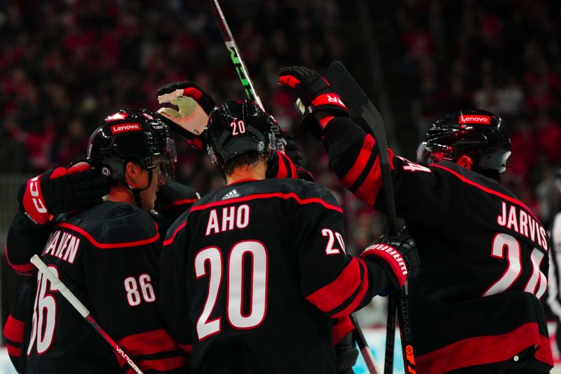 Oct 27, 2023; Raleigh, North Carolina, USA; Carolina Hurricanes left wing Teuvo Teravainen (86) celebrates his goal with center Sebastian Aho (20) and center Seth Jarvis (24) against the San Jose Sharks during the first period at PNC Arena. Mandatory Credit: James Guillory-USA TODAY Sports