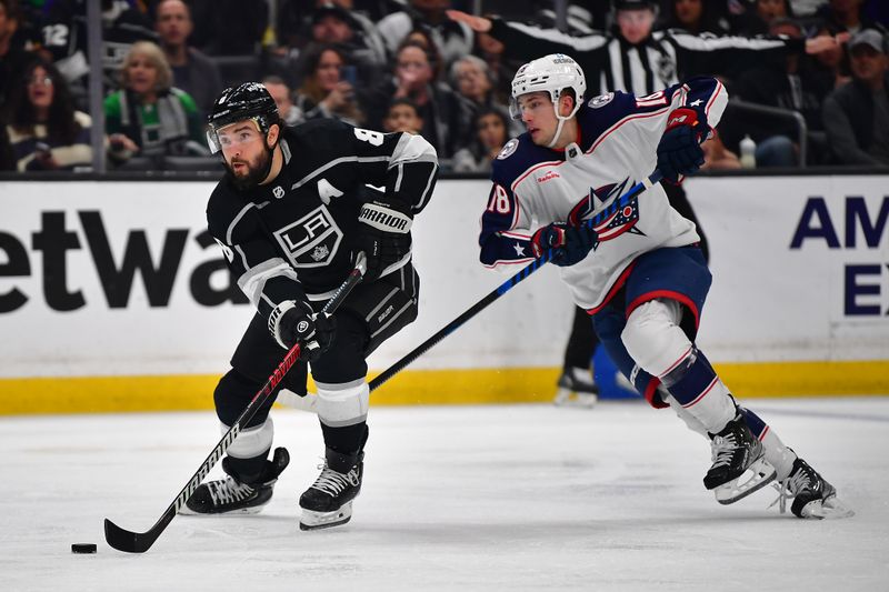 Mar 16, 2023; Los Angeles, California, USA; Los Angeles Kings defenseman Drew Doughty (8) moves the puck ahead of Columbus Blue Jackets center Lane Pederson (18) during the second period at Crypto.com Arena. Mandatory Credit: Gary A. Vasquez-USA TODAY Sports