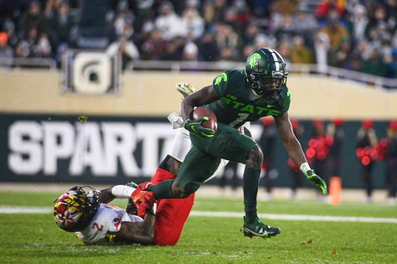 Nov 13, 2021; East Lansing, Michigan, USA;  Michigan State Spartans wide receiver Jayden Reed (1) runs the ball against Maryland Terrapins defensive back Jakorian Bennett (2) during the second quarter at Spartan Stadium. Mandatory Credit: Tim Fuller-USA TODAY Sports