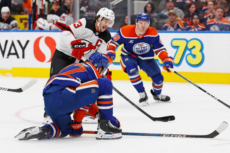 Nov 4, 2024; Edmonton, Alberta, CAN;  Edmonton Oilers defensemen Brett Kulak (27) tries to block a shot by New Jersey Devils forward Nico Hischier (13) during the second periodat Rogers Place. Mandatory Credit: Perry Nelson-Imagn Images