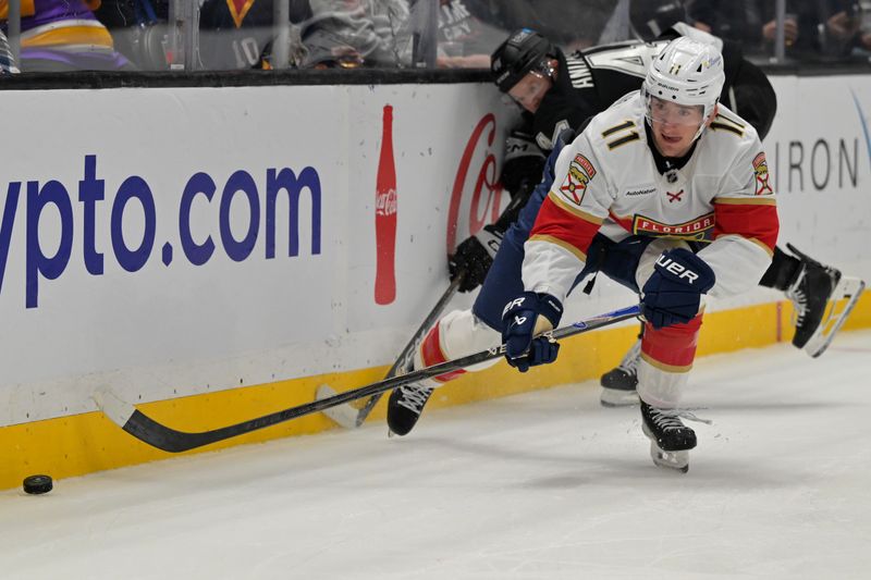 Nov 6, 2025; Los Angeles, California, USA;  Florida Panthers right wing Mackie Samoskevich (11) controls the ball away from Los Angeles Kings defenseman Mikey Anderson (44) in the first period at Crypto.com Arena. Mandatory Credit: Jayne Kamin-Oncea-Imagn Images