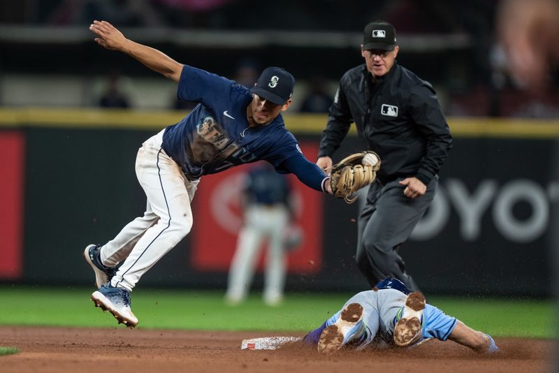 Aug 26, 2024; Seattle, Washington, USA; Tampa Bay Rays third baseman Jose Caballero (7) steals second base ahead of a tag by Seattle Mariners shortstop Leo Rivas (76) during the fifth inning at T-Mobile Park. Mandatory Credit: Stephen Brashear-USA TODAY Sports