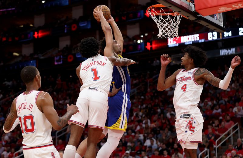 HOUSTON, TEXAS - APRIL 04: Trayce Jackson-Davis #32 of the Golden State Warriors goes up for a dunk against Amen Thompson #1 and Jalen Green #4 of the Houston Rockets in the second half at Toyota Center on April 04, 2024 in Houston, Texas.  NOTE TO USER: User expressly acknowledges and agrees that, by downloading and or using this photograph, User is consenting to the terms and conditions of the Getty Images License Agreement. (Photo by Tim Warner/Getty Images)