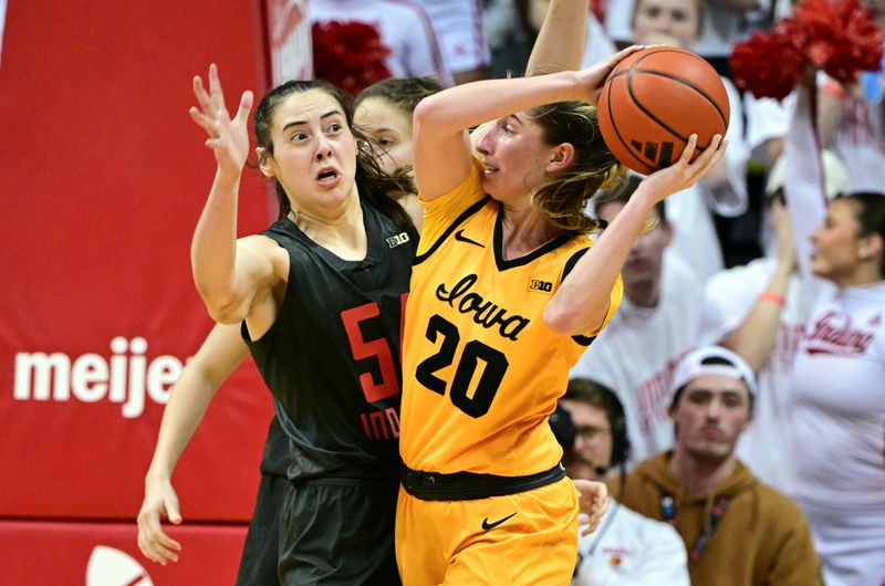 Feb 22, 2024; Bloomington, Indiana, USA; Iowa Hawkeyes guard Kate Martin (20) looks to get a ball past Indiana Hoosiers forward Mackenzie Holmes (54) during the second half at Simon Skjodt Assembly Hall. Mandatory Credit: Marc Lebryk-USA TODAY Sports