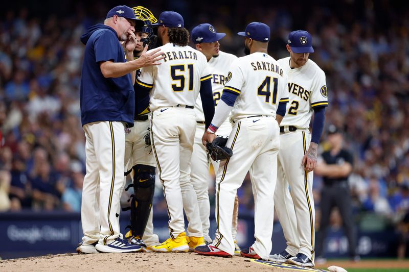 Oct 4, 2023; Milwaukee, Wisconsin, USA; Milwaukee Brewers starting pitcher Freddy Peralta (51) meets on the mound with pitching coach Chris Hook and teammates in the sixth inning against the Arizona Diamondbacks during game two of the Wildcard series for the 2023 MLB playoffs at American Family Field. Mandatory Credit: Kamil Krzaczynski-USA TODAY Sports