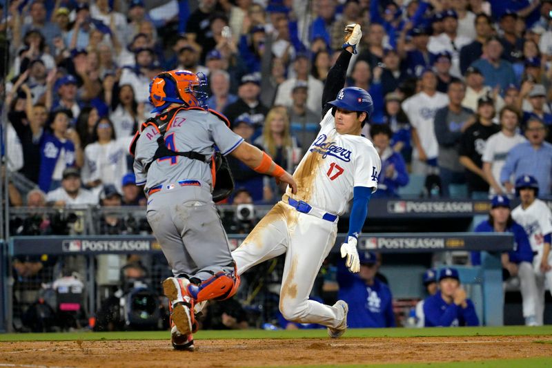 Oct 13, 2024; Los Angeles, California, USA; Los Angeles Dodgers two-way player Shohei Ohtani (17) slides safely at home plate to score a run against New York Mets catcher Francisco Alvarez (4)  in the fourth inning during game one of the NLCS for the 2024 MLB Playoffs at Dodger Stadium. Mandatory Credit: Jayne Kamin-Oncea-Imagn Images