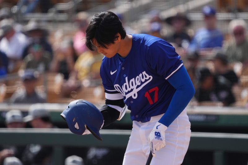 Feb 27, 2024; Phoenix, Arizona, USA; Los Angeles Dodgers designated hitter Shohei Ohtani (17) adjusts his helmet during the first inning against the Chicago White Sox at Camelback Ranch-Glendale. Mandatory Credit: Joe Camporeale-USA TODAY Sports