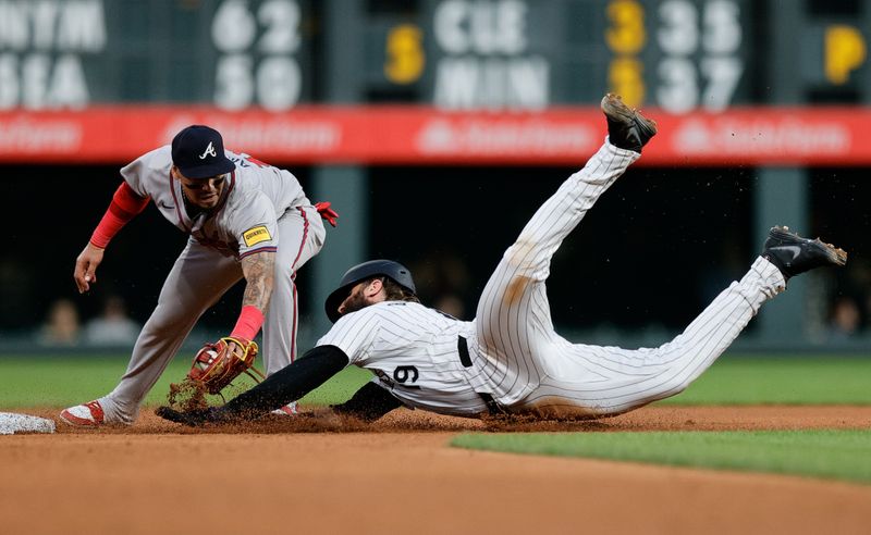 Aug 9, 2024; Denver, Colorado, USA; Colorado Rockies designated hitter Charlie Blackmon (19) advances to second ahead of a tag from Atlanta Braves shortstop Orlando Arcia (11) in the fourth inning at Coors Field. Mandatory Credit: Isaiah J. Downing-USA TODAY Sports