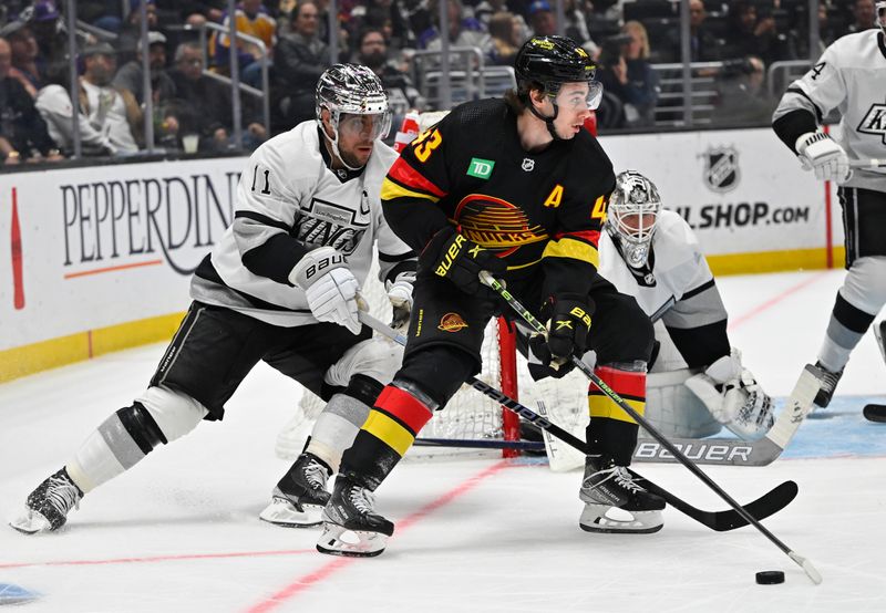 Apr 10, 2023; Los Angeles, California, USA;  Vancouver Canucks defenseman Quinn Hughes (43) takes the puck around the net as he is chased down by Los Angeles Kings center Anze Kopitar (11) in the first period at Crypto.com Arena. Mandatory Credit: Jayne Kamin-Oncea-USA TODAY Sports