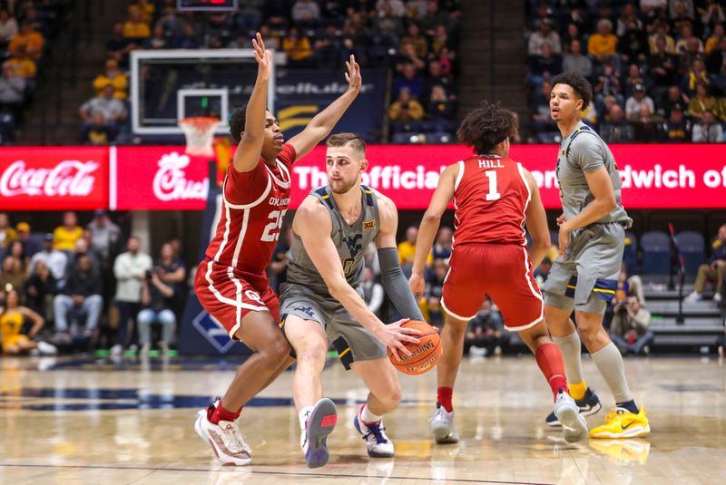 Feb 4, 2023; Morgantown, West Virginia, USA; West Virginia Mountaineers guard Erik Stevenson (10) looks to pass while defended by Oklahoma Sooners guard Grant Sherfield (25) during the second half at WVU Coliseum. Mandatory Credit: Ben Queen-USA TODAY Sports