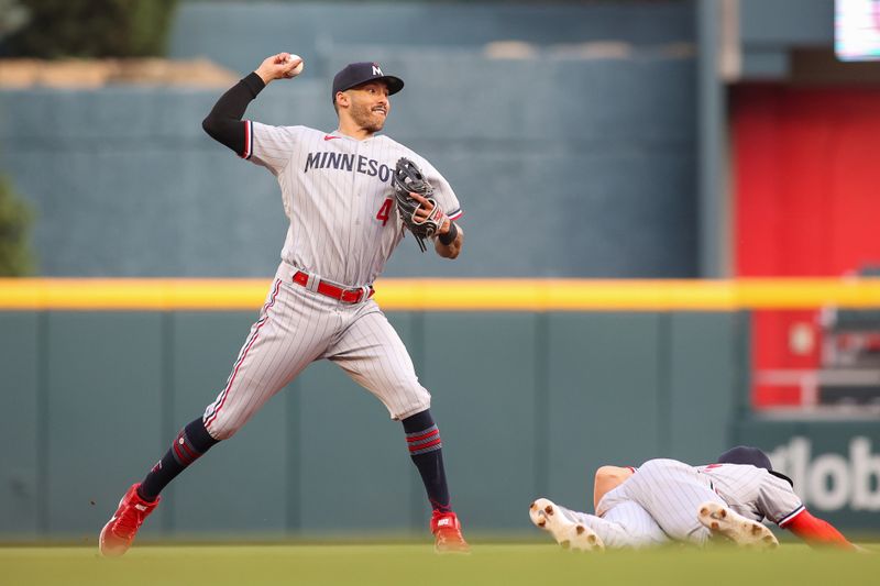 Jun 26, 2023; Atlanta, Georgia, USA; Minnesota Twins shortstop Carlos Correa (4) throws to first over third baseman Kyle Farmer (12) against the Atlanta Braves in the first inning at Truist Park. Mandatory Credit: Brett Davis-USA TODAY Sports