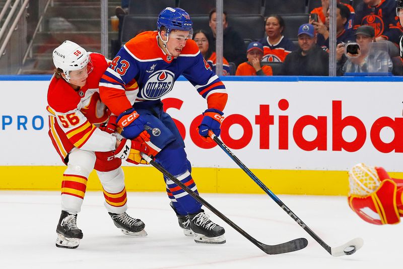 Sep 23, 2024; Edmonton, Alberta, CAN; Edmonton Oilers forward Matvey Petrov (43) protects the puck from Calgary Flames defensemen Henry Mews (56) during the first period at Rogers Place. Mandatory Credit: Perry Nelson-Imagn Images