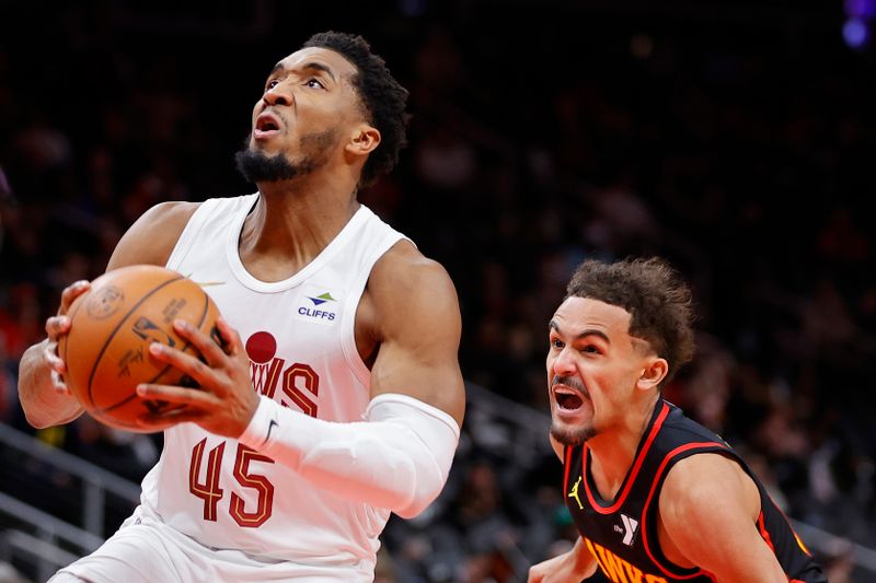 ATLANTA, GEORGIA - JANUARY 20: Donovan Mitchell #45 of the Cleveland Cavaliers drives to the basket over Trae Young #11 of the Atlanta Hawks during the first half at State Farm Arena on January 20, 2024 in Atlanta, Georgia. NOTE TO USER: User expressly acknowledges and agrees that, by downloading and or using this photograph, User is consenting to the terms and conditions of the Getty Images License Agreement. (Photo by Alex Slitz/Getty Images)