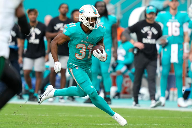 FILE -Miami Dolphins running back Raheem Mostert (31) runs during the second half of an NFL football game against the New York Jets, Sunday, Jan. 8, 2023, in Miami Gardens, Fla. The Miami Dolphins are bringing back running backs Raheem Mostert and Jeff Wilson Jr., agreeing on two-year contracts for both players, Tuesday, March 14, 2023. (AP Photo/Lynne Sladky, File)