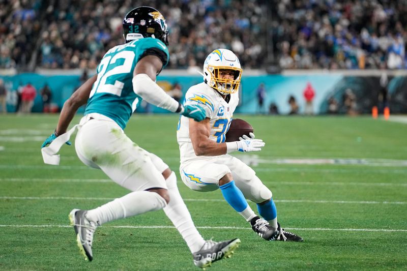 Los Angeles Chargers running back Austin Ekeler (30) heads to the end zone for a touchdown against Jacksonville Jaguars cornerback Tyson Campbell (32) during the first of an NFL wild-card football game, Saturday, Jan. 14, 2023, in Jacksonville, Fla. (AP Photo/Chris Carlson)