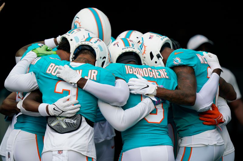 Miami Dolphins players huddle before warming up at a NFL preseason football game against the Las Vegas Raiders, Saturday, August 20, 2022, in Miami Gardens, Fla. (AP Photo/Wilfredo Lee)