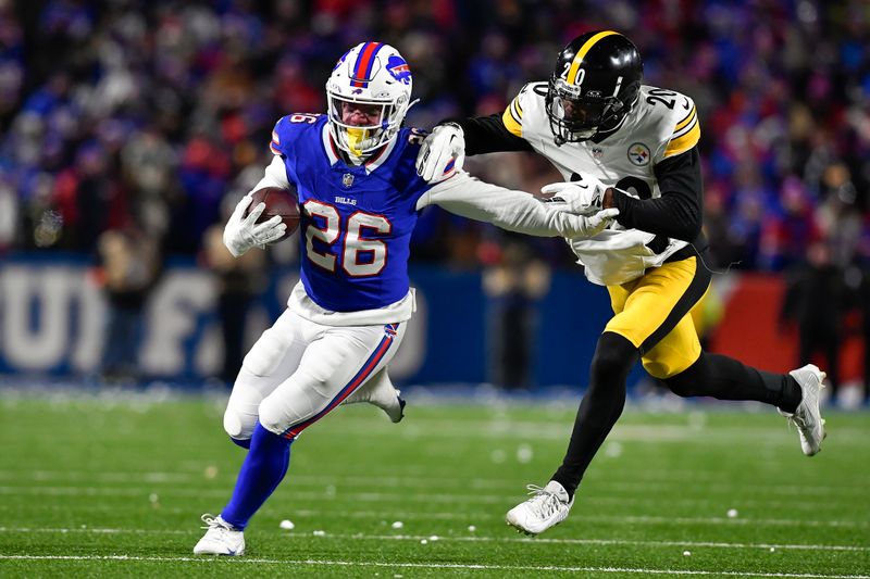 Buffalo Bills running back Ty Johnson (26) tries to avoid a tackle by Pittsburgh Steelers cornerback Patrick Peterson (20) during the second half of an NFL wild-card playoff football game in Orchard Park, N.Y., Monday, Jan. 15, 2024. (AP Photo/Adrian Kraus)