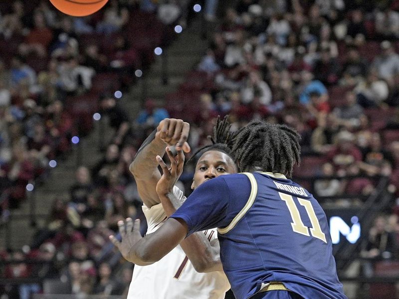 Jan 18, 2025; Tallahassee, Florida, USA;  Florida State Seminoles forward Jamyr Watkins (1) passes the ball past Georgia Tech Yellowjackets forward Baye Ndongo (11) during the second half at Donald L. Tucker Center. Mandatory Credit: Robert Myers-Imagn Images