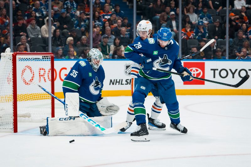 Oct 3, 2025; Vancouver, British Columbia, CAN; Vancouver Canucks goalie Thatcher Demko (35) makes a save as Edmonton Oilers forward Noah Philp (48) battles with defenseman Marcus Pettersson (29) in the second period at Rogers Arena. Mandatory Credit: Bob Frid-Imagn Images