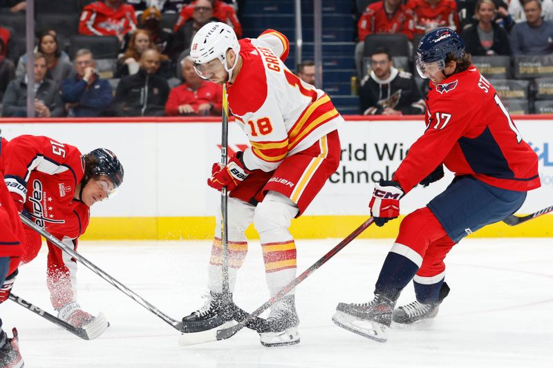 Oct 16, 2023; Washington, District of Columbia, USA; Calgary Flames left wing A.J. Greer (18) battle for the puck with Washington Capitals left wing Sonny Milano (15) and Capitals center Dylan Strome (17) in the second period at Capital One Arena. Mandatory Credit: Geoff Burke-USA TODAY Sports