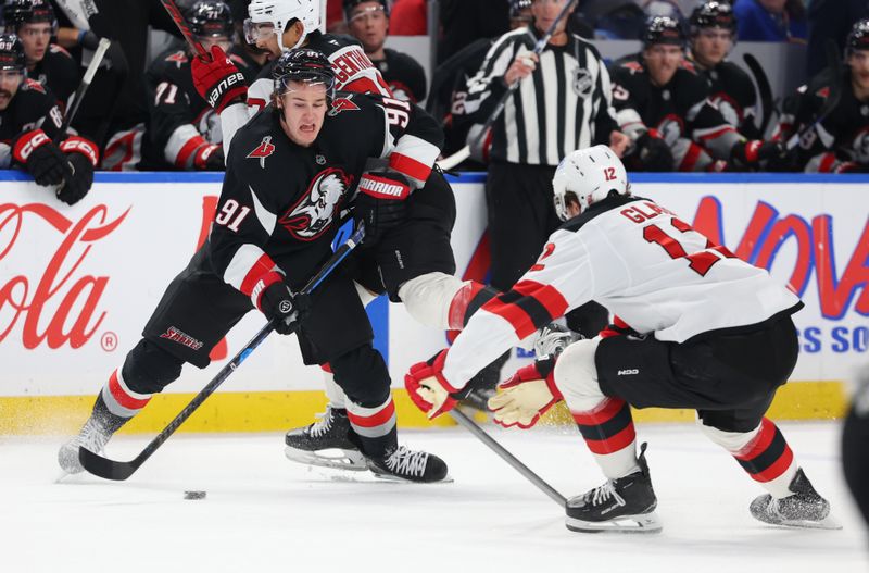 Nov 28, 2025; Buffalo, New York, USA;  Buffalo Sabres right wing Josh Doan (91) plays the puck as New Jersey Devils center Cody Glass (12) defends during the second period at KeyBank Center. Mandatory Credit: Timothy T. Ludwig-Imagn Images