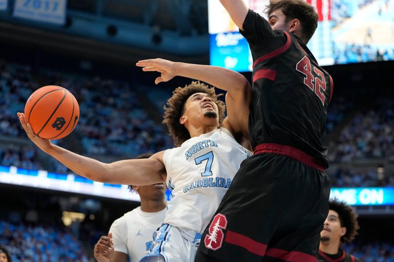 Jan 18, 2025; Chapel Hill, North Carolina, USA; North Carolina Tar Heels guard Seth Trimble (7) shoots as Stanford Cardinal forward Maxime Raynaud (42) defends in the second half at Dean E. Smith Center. Mandatory Credit: Bob Donnan-Imagn Images