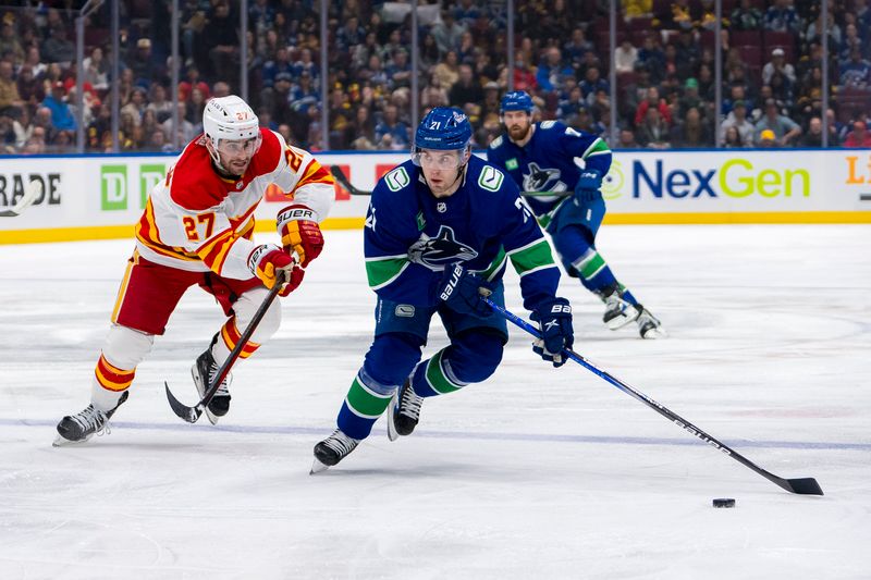 Apr 16, 2024; Vancouver, British Columbia, CAN; Vancouver Canucks forward Nils Hoglander (21) drives past Calgary Flames forward Matt Coronato (27) in the first period at Rogers Arena. Mandatory Credit: Bob Frid-USA TODAY Sports