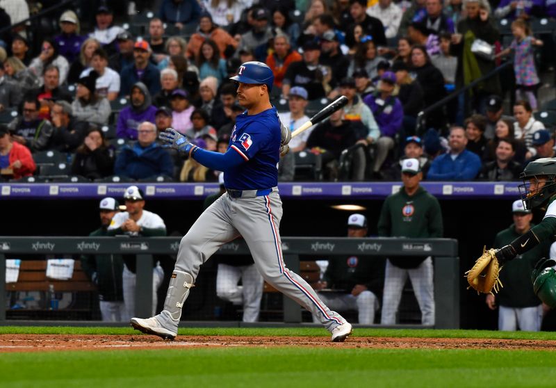 May 11, 2024; Denver, Colorado, USA;  Texas Rangers first base Nathaniel Lowe (30) hits a single against the Colorado Rockies during the fifth inning at Coors Field. Mandatory Credit: John Leyba-USA TODAY Sports