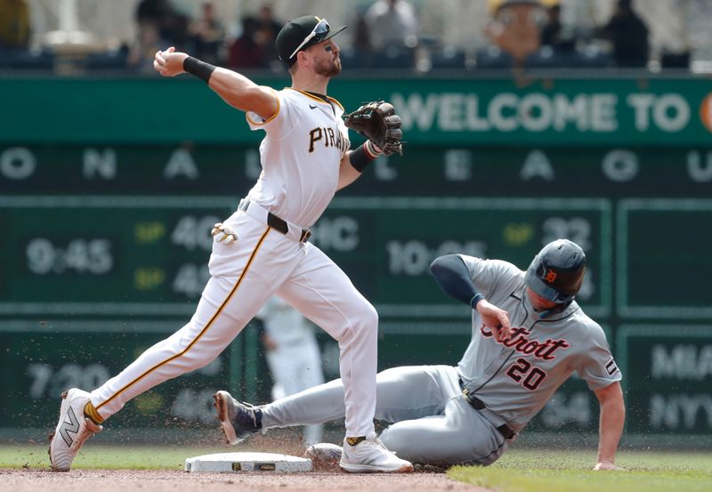 Apr 9, 2024; Pittsburgh, Pennsylvania, USA;  Pittsburgh Pirates second baseman Jared Triolo (19) turns a double play over Detroit Tigers first baseman Spencer Torkelson (20) to end the first inning at PNC Park. Mandatory Credit: Charles LeClaire-USA TODAY Sports