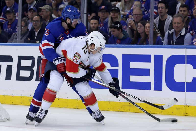 May 22, 2024; New York, New York, USA; New York Rangers defenseman Ryan Lindgren (55) and Florida Panthers center Anton Lundell (15) fight for the puck during the second period of game one of the Eastern Conference Final of the 2024 Stanley Cup Playoffs at Madison Square Garden. Mandatory Credit: Brad Penner-USA TODAY Sports