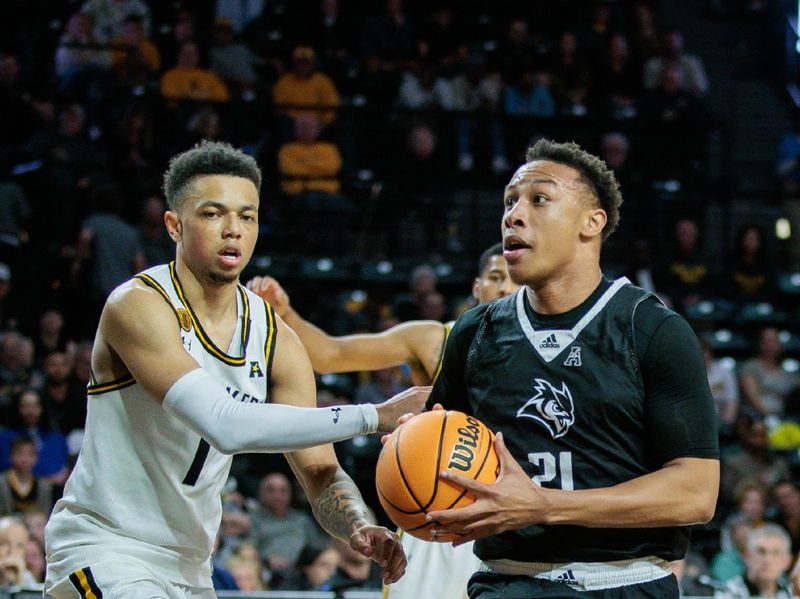 Mar 2, 2024; Wichita, Kansas, USA; Rice Owls guard Gabe Warren (21) drives to the basket around Wichita State Shockers guard Xavier Bell (1) during the second half at Charles Koch Arena. Mandatory Credit: William Purnell-USA TODAY Sports