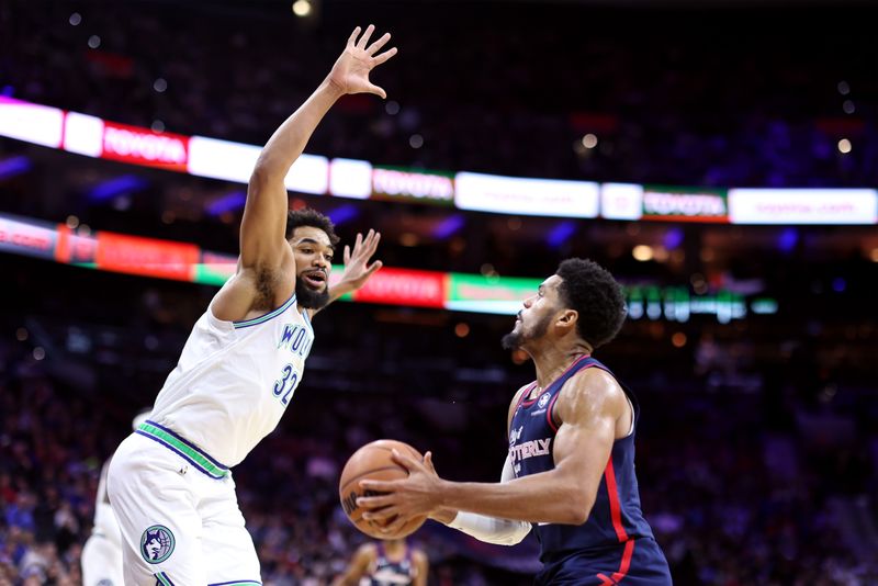 PHILADELPHIA, PENNSYLVANIA - DECEMBER 20: Karl-Anthony Towns #32 of the Minnesota Timberwolves guards Tobias Harris #12 of the Philadelphia 76ers during the second quarter at the Wells Fargo Center on December 20, 2023 in Philadelphia, Pennsylvania. NOTE TO USER: User expressly acknowledges and agrees that, by downloading and or using this photograph, User is consenting to the terms and conditions of the Getty Images License Agreement. (Photo by Tim Nwachukwu/Getty Images)