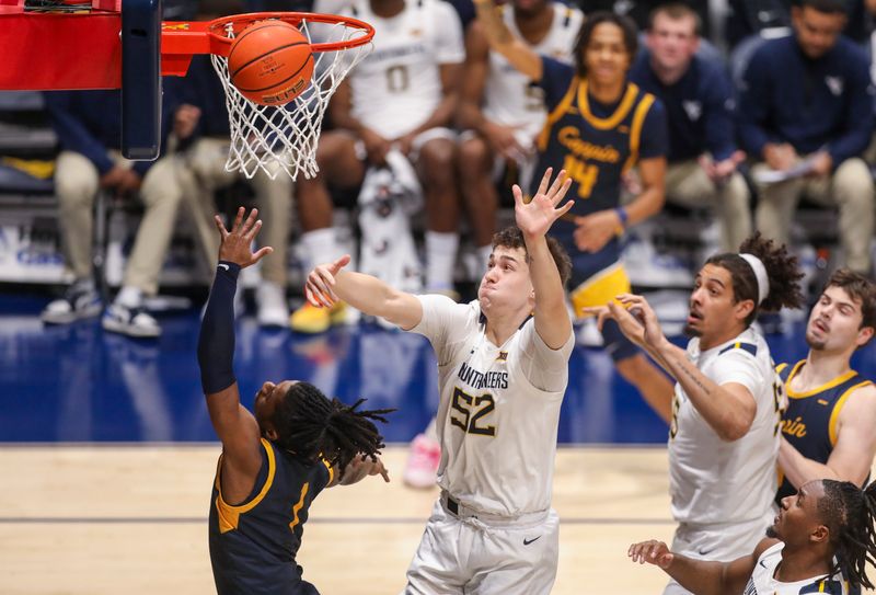 Dec 3, 2025; Morgantown, West Virginia, USA; Coppin State Eagles guard Hassan Perkins (1) shoots against West Virginia Mountaineers guard Treysen Eaglestaff (52) during the first half at Hope Coliseum. Mandatory Credit: Ben Queen-Imagn Images