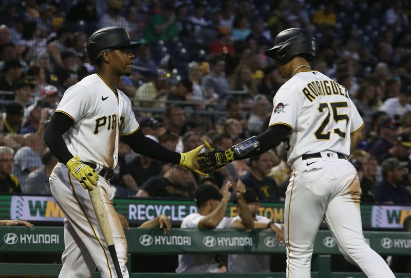 Aug 9, 2023; Pittsburgh, Pennsylvania, USA;  Pittsburgh Pirates third baseman Ke'Bryan Hayes (left) celebrates with catcher Endy Rodriguez (25) after Rodriguez scored a run against the Atlanta Braves during the fourth inning at PNC Park. Mandatory Credit: Charles LeClaire-USA TODAY Sports