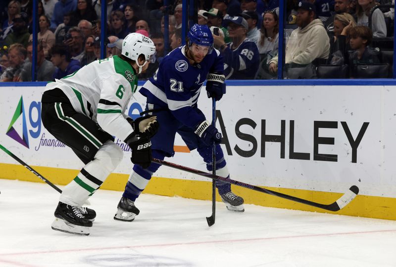 Oct 30, 2025; Tampa, Florida, USA; Tampa Bay Lightning center Brayden Point (21) skates with the puck as Dallas Stars defenseman Lian Bichsel (6) defends during the first period at Benchmark International Arena. Mandatory Credit: Kim Klement Neitzel-Imagn Images