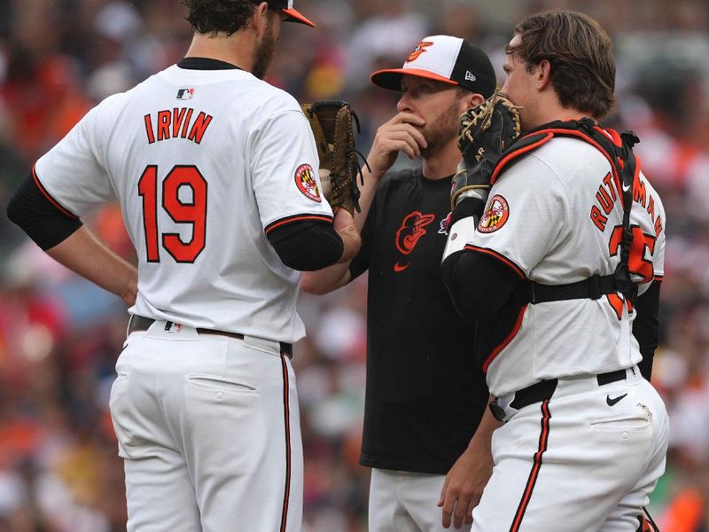 May 27, 2024; Baltimore, Maryland, USA; Baltimore Orioles starting pitcher Cole Irvin (left) talks with pitching coach Drew French (center) and catcher Adley Rutschman (right) during a second inning mound visit against the Boston Red Sox at Oriole Park at Camden Yards. Mandatory Credit: Mitch Stringer-USA TODAY Sports