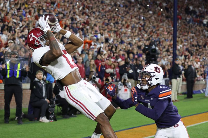 Nov 25, 2023; Auburn, Alabama, USA;  Alabama Crimson Tide wide receiver Isaiah Bond (17) scores the game winning touchdown over Auburn Tigers cornerback D.J. James (4) during the fourth quarter at Jordan-Hare Stadium. Mandatory Credit: John Reed-USA TODAY Sports