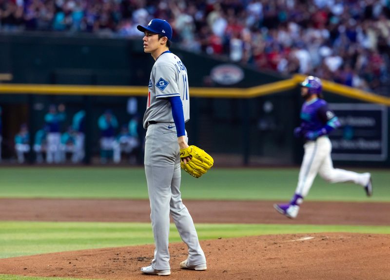 May 9, 2025; Phoenix, Arizona, USA; Los Angeles Dodgers pitcher Roki Sasaki reacts after giving up a home run to Arizona Diamondbacks third baseman Eugenio Suarez in the first inning at Chase Field. Mandatory Credit: Mark J. Rebilas-Imagn Images