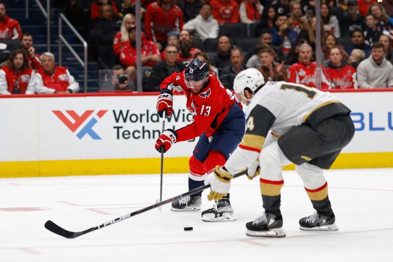 Oct 15, 2024; Washington, District of Columbia, USA; Washington Capitals left wing Jakub Vrana (13) passes the puck s Vegas Golden Knights defenseman Nicolas Hague (14) defends in the third period at Capital One Arena. Mandatory Credit: Geoff Burke-Imagn Images