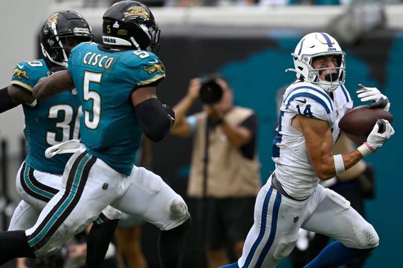 Indianapolis Colts wide receiver Alec Pierce (14) catches a pass as Jacksonville Jaguars safety Andre Cisco (5) and cornerback Montaric Brown (30) defend during the second half of an NFL football game, Sunday, Oct. 6, 2024, in Jacksonville, Fla. (AP Photo/Phelan M. Ebenhack)