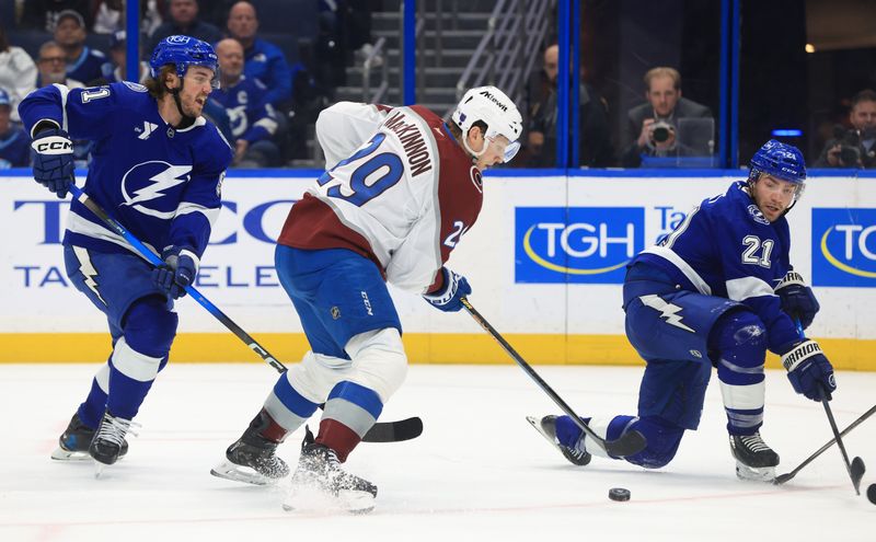 Jan 6, 2026; Tampa, Florida, USA; Colorado Avalanche center Nathan MacKinnon (29) skates with the puck as Tampa Bay Lightning center Brayden Point (21) defends during the second period at Benchmark International Arena. Mandatory Credit: Kim Klement Neitzel-Imagn Images