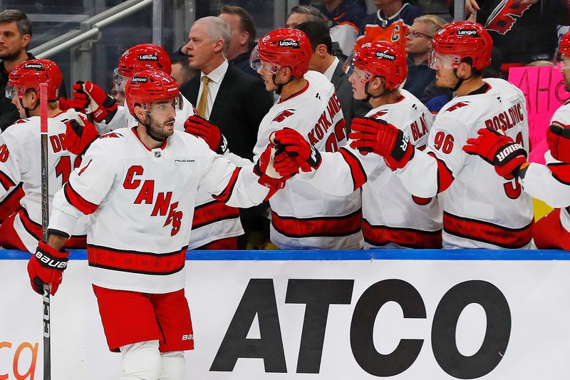 Oct 22, 2024; Edmonton, Alberta, CAN;  The Carolina Hurricanes celebrate a goal scored by defensemen Shayne Gostisbehere (4) during the third period against the Edmonton Oilers at Rogers Place. Mandatory Credit: Perry Nelson-Imagn Images