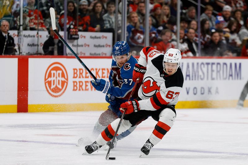 Feb 26, 2025; Denver, Colorado, USA; New Jersey Devils left wing Jesper Bratt (63) controls the puck ahead of Colorado Avalanche center Casey Mittelstadt (37) in the second period at Ball Arena. Mandatory Credit: Isaiah J. Downing-Imagn Images