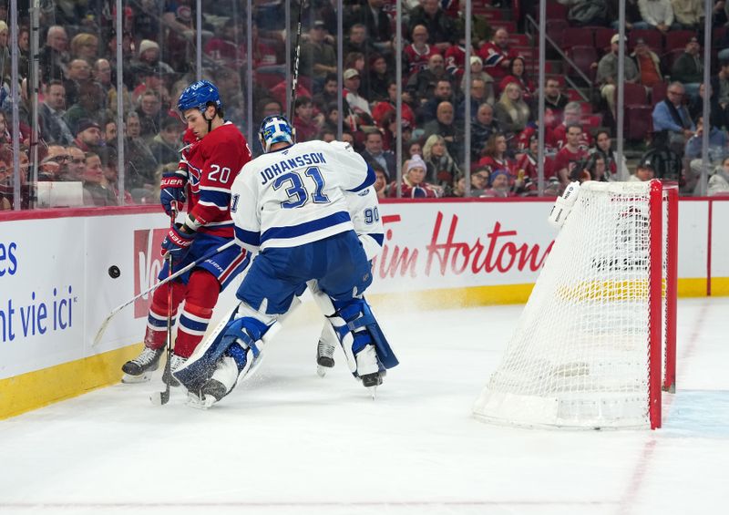 Dec 9, 2025; Montreal, Quebec, CAN; Montreal Canadiens forward Juraj Slafkovsky (20) takes the puck away from Tampa Bay Lightning goalie Jonas Johansson (31) during the second period at the Bell Centre. Mandatory Credit: Eric Bolte-Imagn Images