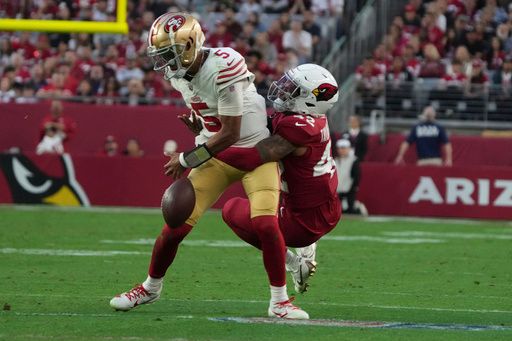 San Francisco 49ers quarterback Joshua Dobbs (5) fumbles the ball as he is hit by Arizona Cardinals safety Dadrion Taylor-Demerson (42) during the second half of an NFL football game in Glendale, Ariz., Sunday, Jan. 5, 2025. (AP Photo/Rick Scuteri)