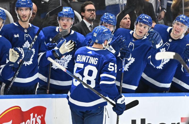 Jan 3, 2023; Toronto, Ontario, CAN;  Toronto Maple Leafs forward Michael Bunting (58) celebrates at the bench with teammates after scoring against the St. Louis Blues in the third period at Scotiabank Arena. Mandatory Credit: Dan Hamilton-USA TODAY Sports