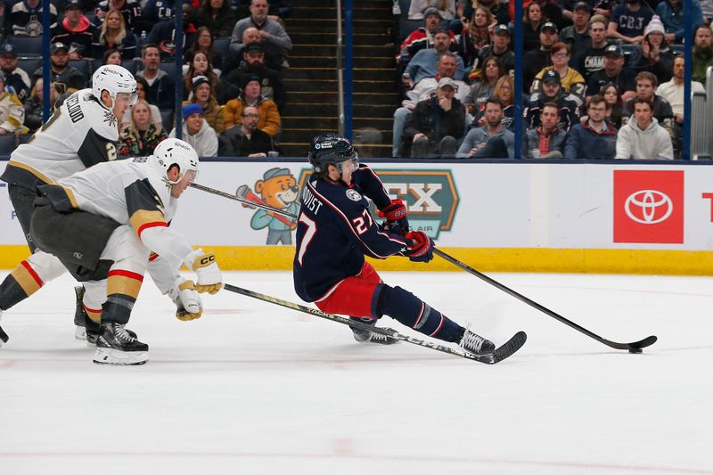 Mar 4, 2024; Columbus, Ohio, USA; Columbus Blue Jackets defenseman Adam Boqvist (27) shoots on gaol as he falls to the ice against the Vegas Golden Knights during the second period at Nationwide Arena. Mandatory Credit: Russell LaBounty-USA TODAY Sports