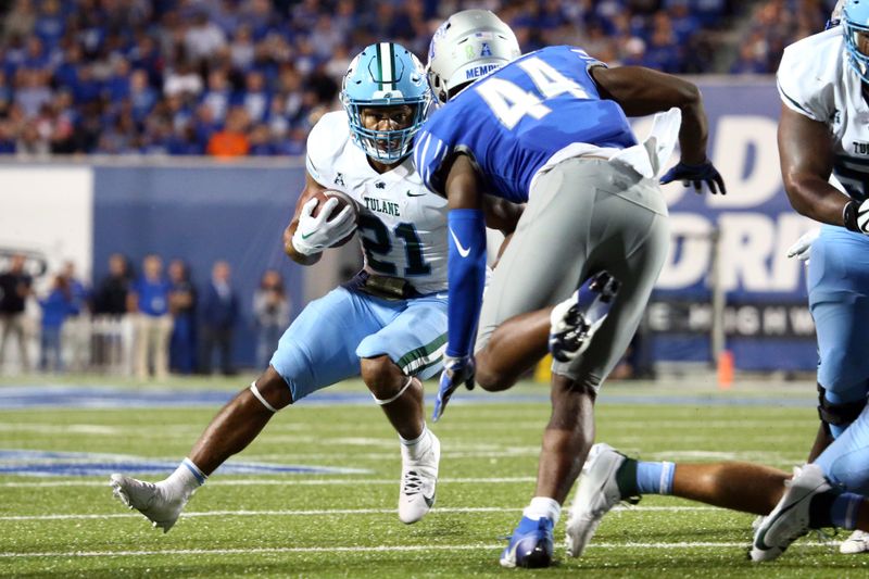 Oct 13, 2023; Memphis, Tennessee, USA; Tulane Green Wave running back Makhi Hughes (21) runs with the ball as Memphis Tigers linebacker Bryce Edmondson (44) makes the tackle during the first half at Simmons Bank Liberty Stadium. Mandatory Credit: Petre Thomas-USA TODAY Sports