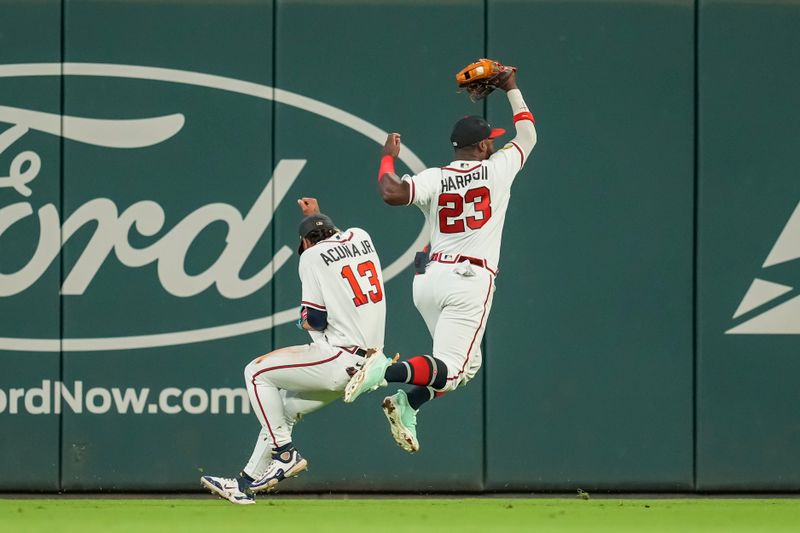 Sep 27, 2023; Cumberland, Georgia, USA; Atlanta Braves center fielder Michael Harris II (23) catches a fly ball hit by Chicago Cubs left fielder Ian Happ (8) (not shown) over right fielder Ronald Acuna Jr. (13) during the tenth inning at Truist Park. Mandatory Credit: Dale Zanine-USA TODAY Sports